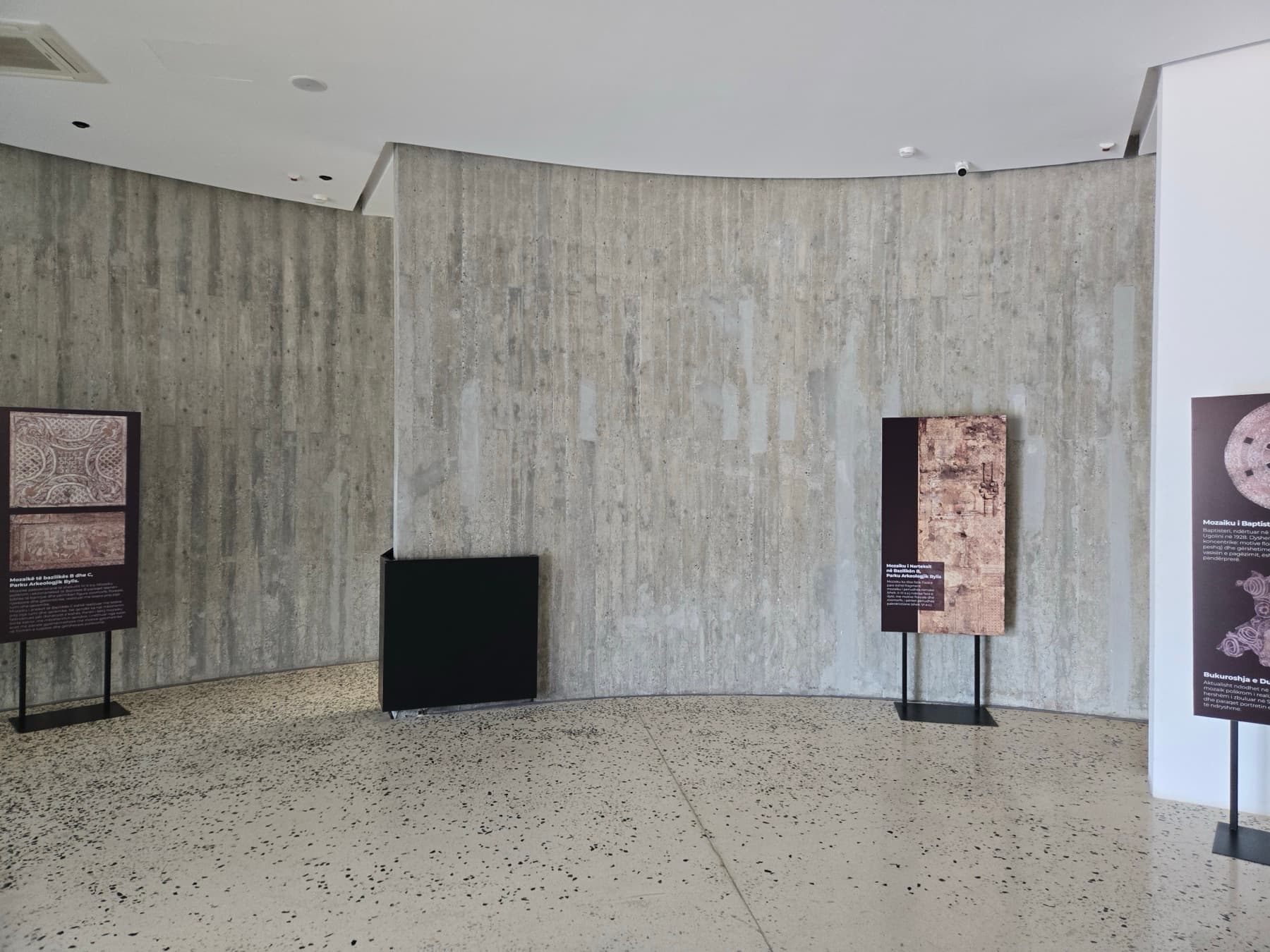 Curved concrete gallery wall with information panels.